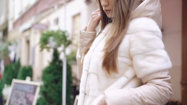 Perfil da menina na moda posando para câmera em casaco de peles na rua 4K — Vídeo de Stock