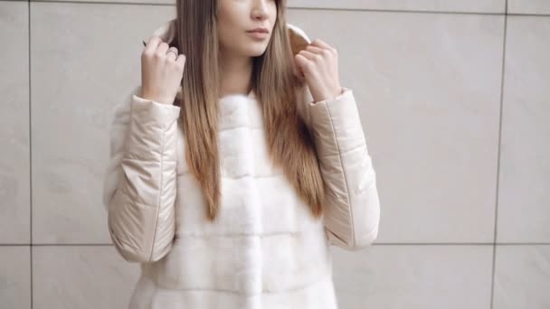 Muodikas tyttö poseeraa turkissa kadulla 4K — kuvapankkivideo