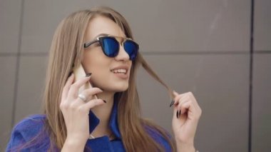 Akıllı telefonda konuşan ve 4 k gülümseyen moda bayan