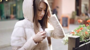 Duman kahve içme ve sokakta gülümseyen akıllı kız. 4k
