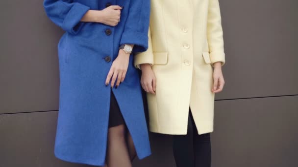 Stylish models posing to camera in coats near the wall 4K — Αρχείο Βίντεο