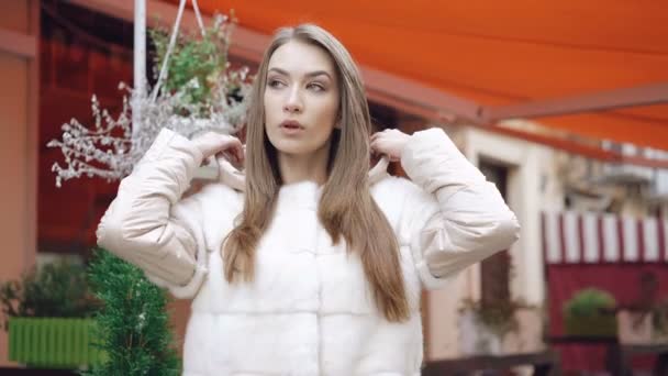 Elegáns modell pózol a kamera a bundáját, az utcai 4 k — Stock videók
