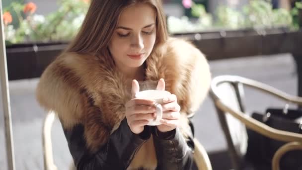 Retrato de una chica inteligente tomando una taza de café caliente en la cafetería. 4K — Vídeo de stock