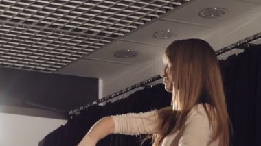 Akıllı kız butik içinde zengin beyaz kürk manto üzerinde çalışıyor