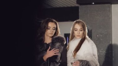 İki zengin kız poz ve kürk catwalking