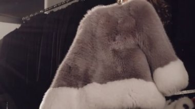 Zengin kürk manto üzerinde çalışıyor ve butik kamerada poz akıllı kız