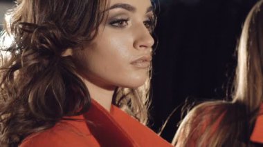 İki model tribünlerde poz reklam için zengin kırmızı renk paltolar. Yavaş yavaş