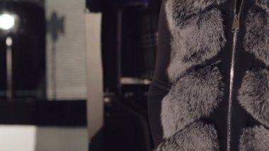 Akıllı modeli zengin kürklü mantolar reklam için poz duruyor. Yavaş yavaş