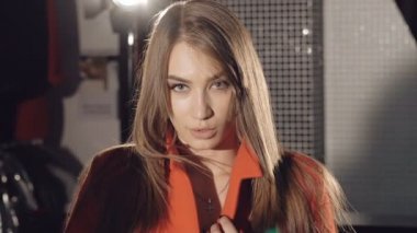 Tutkulu bir model kırmızı ceket flört catwalking. Yavaş yavaş