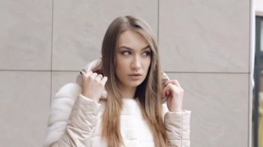 Kameraya bakarak ve kaputu giyen sevimli kadın