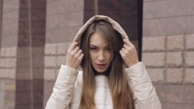 Kameraya bakarak ve kaputu giyen güzel bir kadın