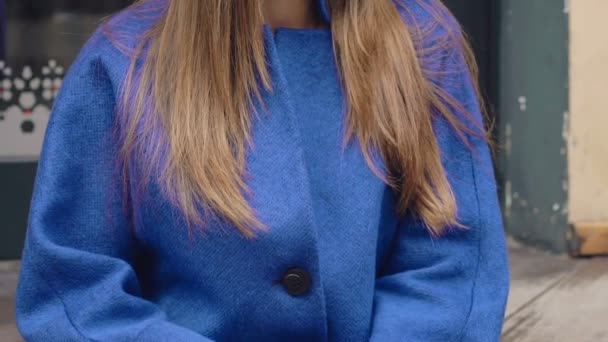 Όμορφο κορίτσι σε μπλε παλτό που παρουσιάζουν στις εξωτερικές σκάλες — Αρχείο Βίντεο