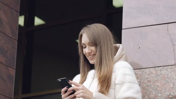 Menina bonita usando telefone perto do escritório ao ar livre — Vídeo de Stock