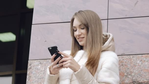 Mujer bonita tomando una selfie cerca del edificio — Vídeo de stock