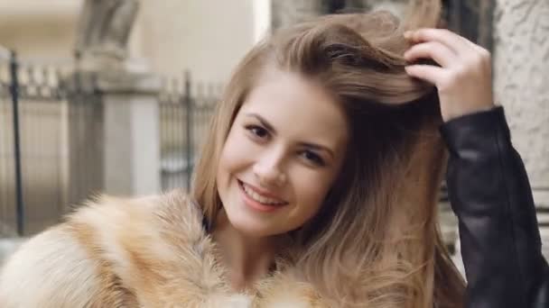 Ładna dziewczyna pozuje w futrzany płaszcz na ulicy — Wideo stockowe