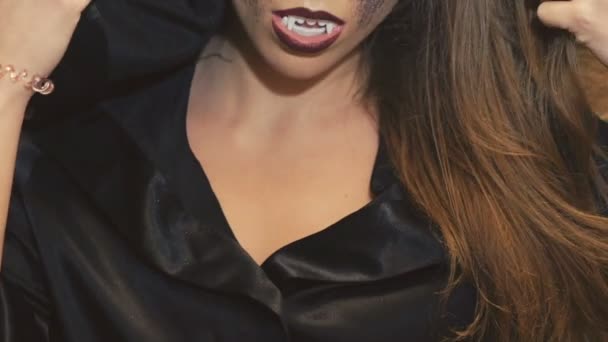 Femmina incantatrice nel cappotto nero spaventando con i denti sulla macchina fotografica — Video Stock