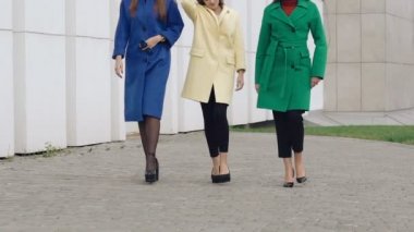 Üç mutlu kadın sokakta kaşmir yün palto pist yürür. Yavaş yavaş