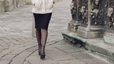 Kürklü ceket güzel kadın sokakta pist yürür. Yavaş yavaş
