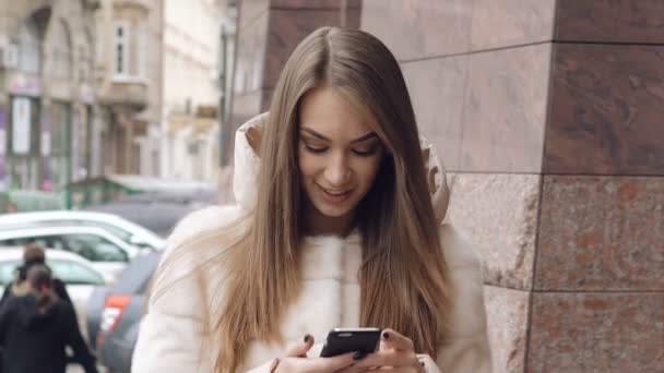 Una chica bonita usando el teléfono cerca de la oficina. Despacio. — Vídeos de Stock