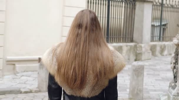 Volver mirada de chica linda caminar y se da la vuelta en la calle. Despacio. — Vídeo de stock