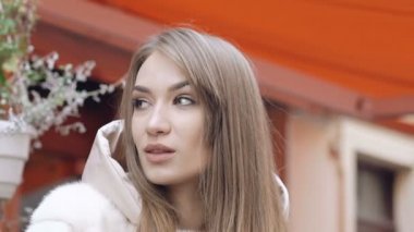 Tutkulu kadın kürklü ceket poz ve bir yana görünüyor. Yavaş yavaş