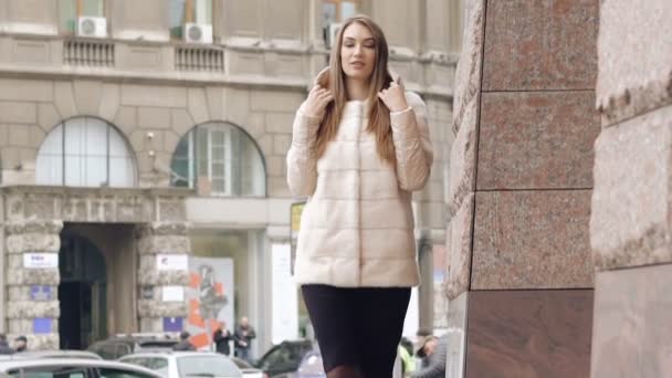 毛皮のコートでスタイリッシュな女性は、路上で滑走路を歩きます。ゆっくりと — ストック動画