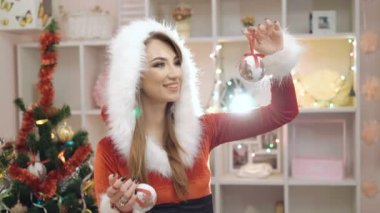 Mutlu kadın gülümseyerek ve 4 k'dan fazla Chirstmas oyuncak kullanarak glamour takım elbise giymiş