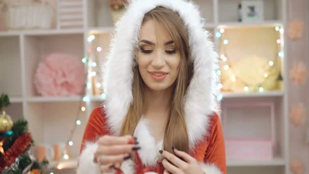 Mujer feliz vestida con traje de doncella de nieve mostrando el juguete de Navidad en 4K — Vídeos de Stock