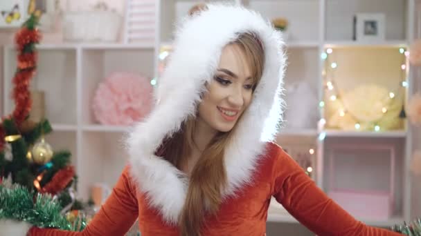 Woman dressed in snow-maiden suit embracing with Christmas decoration in 4K — Stockvideo