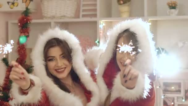 Twee feestelijke meisje dansen op camera met wonderkaarsen in hun handen — Stockvideo