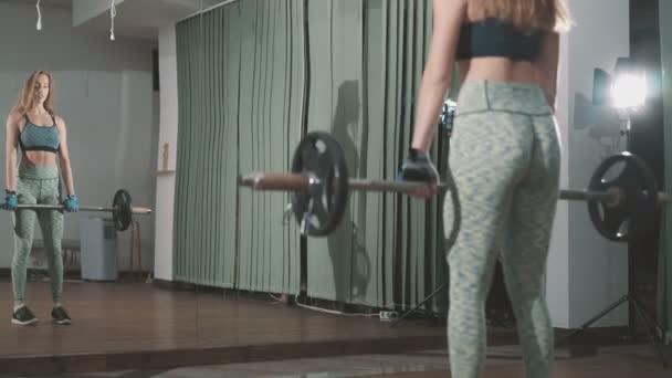 Красивая молодая женщина поднимает тяжести — стоковое видео