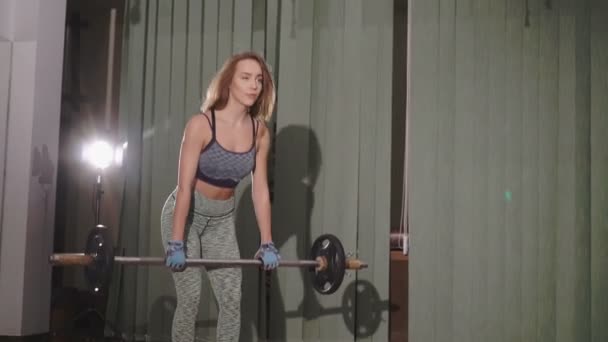 Schöne junge Frau beim Heben von Gewichten — Stockvideo
