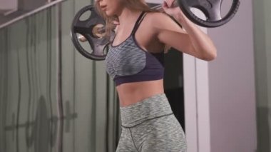 Onun omuzlarında ağır ağırlıklar ile Halter ile çalışan genç kadın