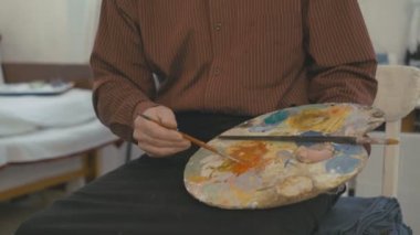 Gri eski ressam gülümseyerek ve 4 k fotoğraf makinesinde seyir bıyıklı portresi