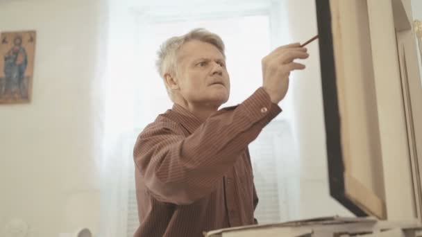 Retrato de viejo pintor gris con bigote dibuja la obra maestra en 4K — Vídeos de Stock