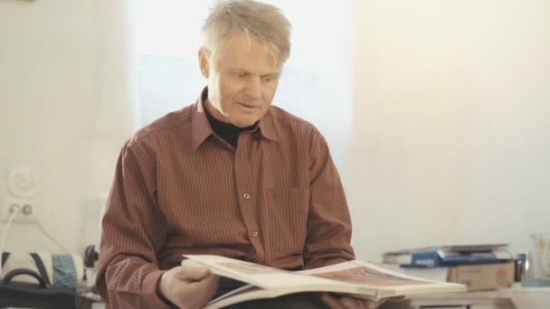 Portrait of old painter fliping through the album and looking on camera in 4K — Stock Video