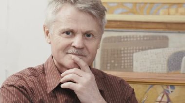 yaşlı adam kameraya bakıyor