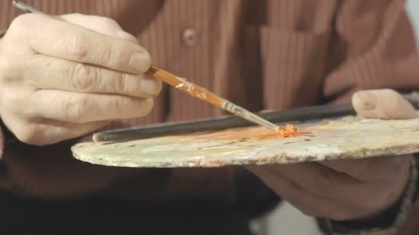 The painters hand mixes paint on the palette — Stock Video