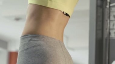 İnce kız spor salonunda yatay çubuğu egzersizleri yapıyor