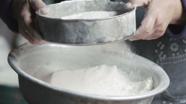 Masada kaseye Un Eleme eski kırışmış eller yukarı kapatın. Ağır çekim