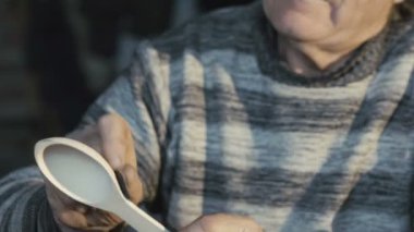 Eski tahta kaşık yapma ve kameraya gülümseyen marangoz buruşuk