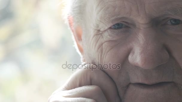 Крупным планом портрет уставшего счастливого старика улыбающегося в камеру — стоковое видео