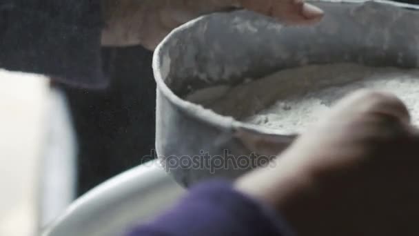 Close up of old wrinkled womans hands sifting flour — Stock Video