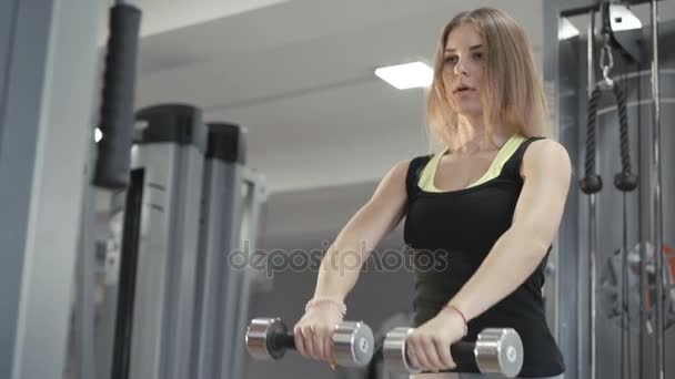 Chica fuerte haciendo ejercicio con tonta campana para los músculos delta en 4K — Vídeo de stock