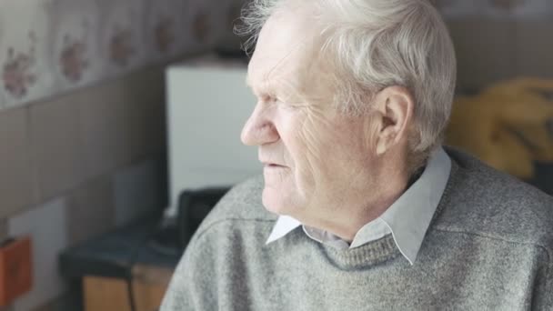 Viejo abuelo mirando a la ventana y la cámara 4K — Vídeo de stock