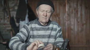 Onun el yapımı tahta kaşık katmanlarıdır ve 4 k kameraya gülümseyen adam yaşlı buruşuk