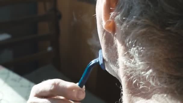 Barbe à raser senior à la maison par lui-même dans le village 4K — Video