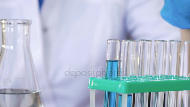 Primer plano Vídeo Full HD del científico poniendo gotas de sustancia química en el tubo de ensayo — Vídeo de stock