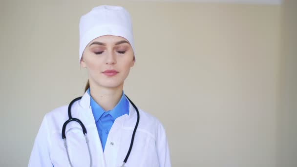 Portret van een jonge volwassen vrouwelijke arts, camera kijken en glimlachen — Stockvideo