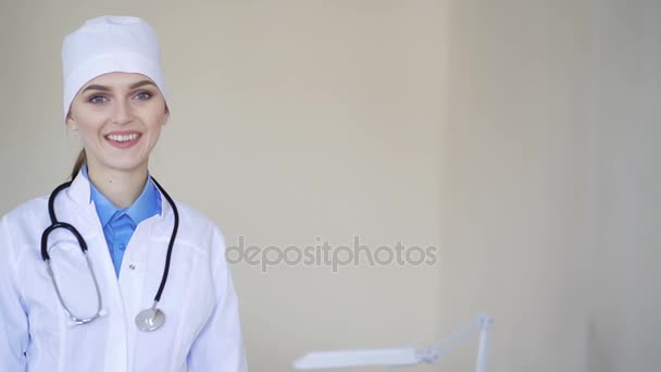 Πορτρέτο του ένας νεαρός γιατρός ενηλίκων γυναικών, βλέπουν φωτογραφική μηχανή και χαμογελαστός — Αρχείο Βίντεο